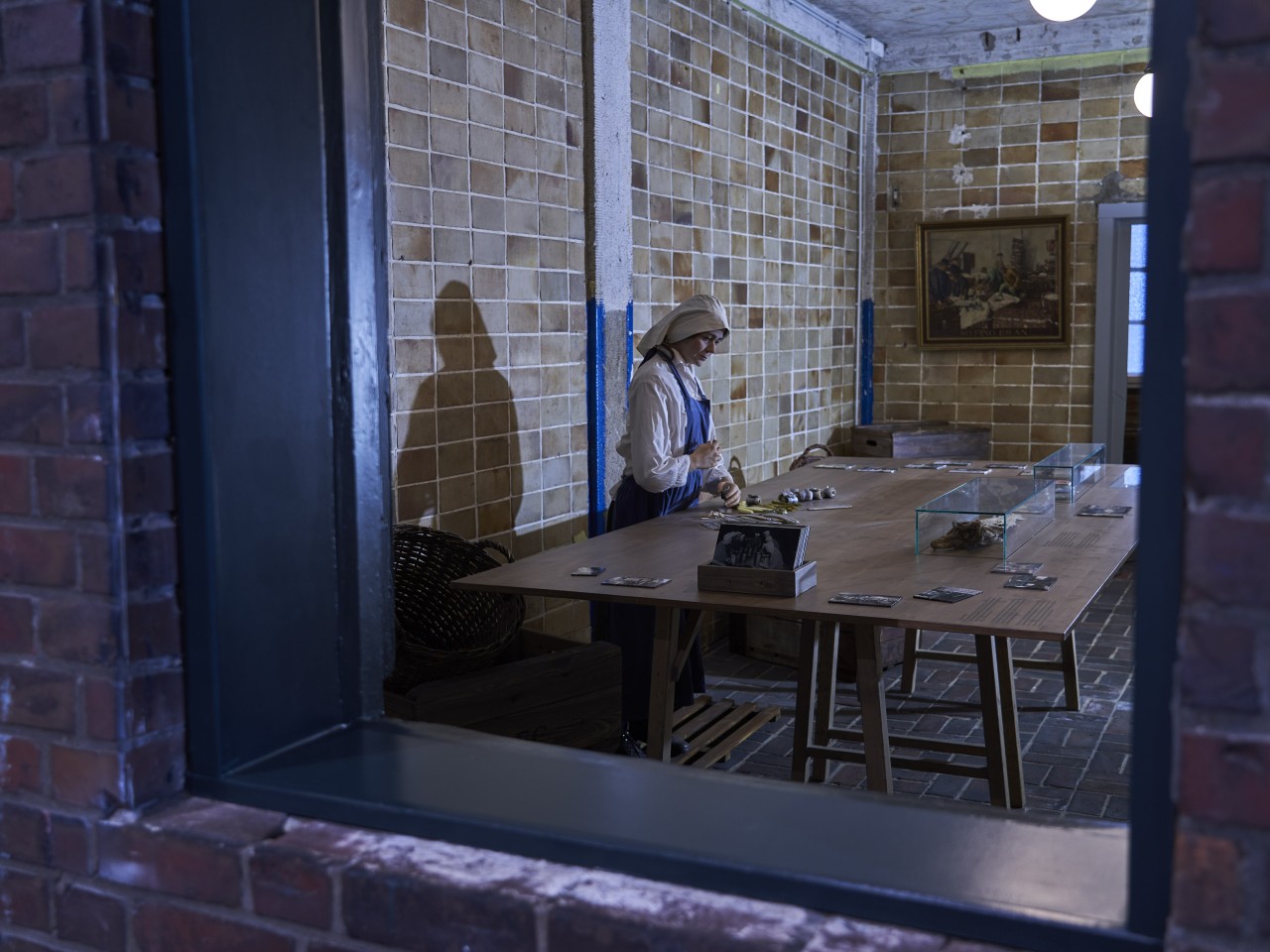 Inszenierung einer Fischwerkerin, die Rollmöpse wickelt