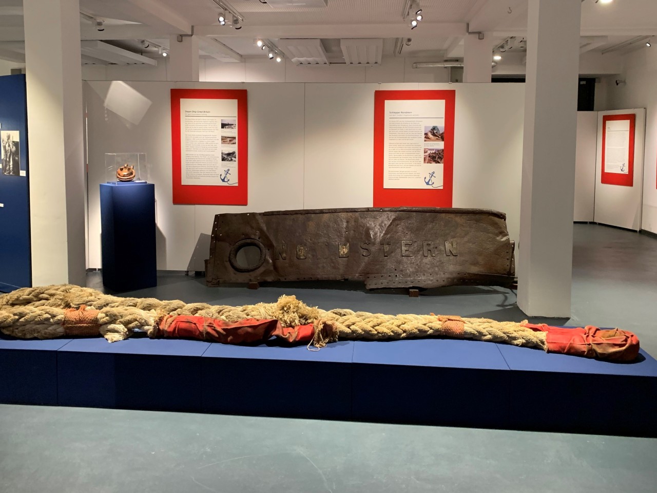 Recker vor einem Stück Bordwand des Schleppers Nordstern